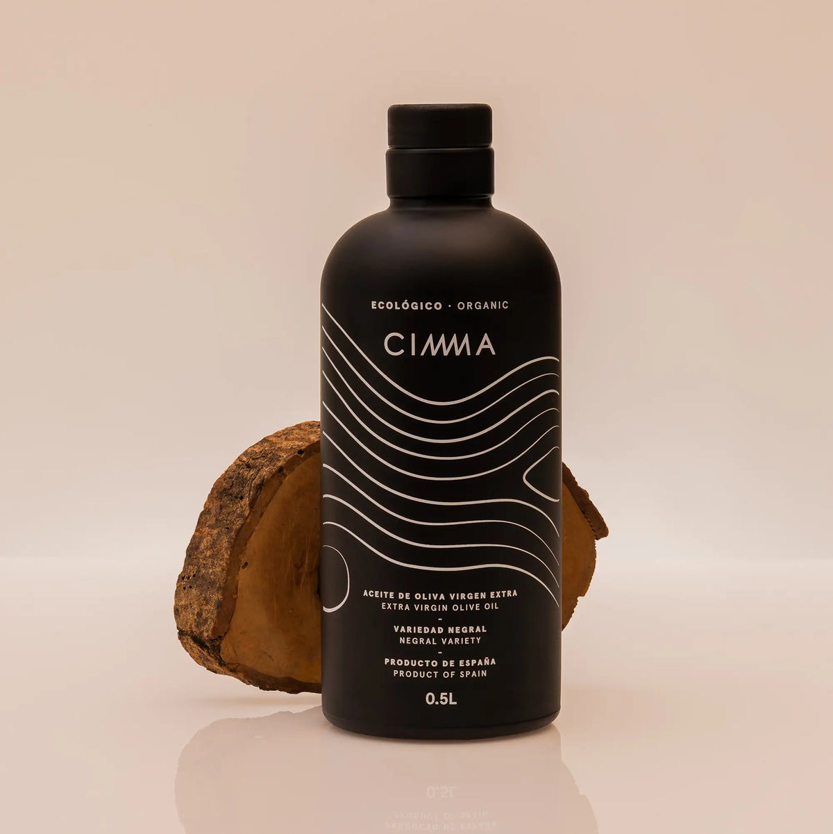 Botella de AOVE Negral ecológico CIMMA con fondo beige y madera
